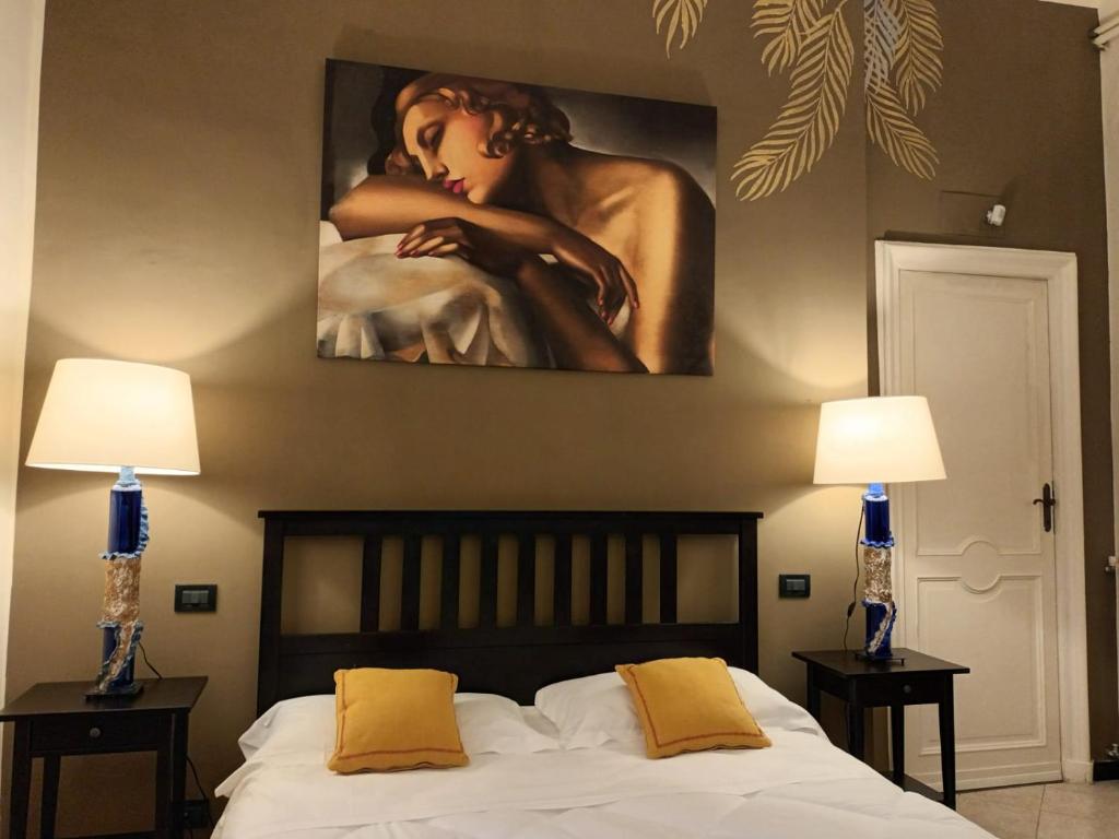 - une chambre avec un tableau au-dessus d'un lit et 2 lampes dans l'établissement B&B Genova Centro, à Gênes