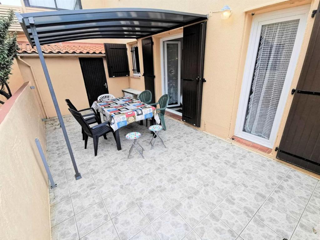 un patio avec une table et des chaises dessus dans l'établissement Résidence Les Sablons Et - Pièces 214, à Leucate