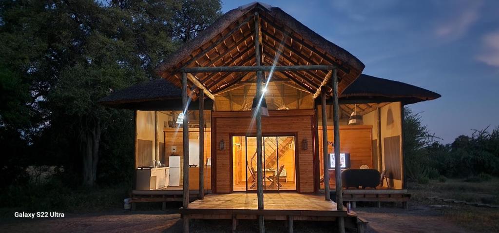 una pequeña casa con techo en una terraza de madera en Hippo Lagoon Cabin, en Ntabis