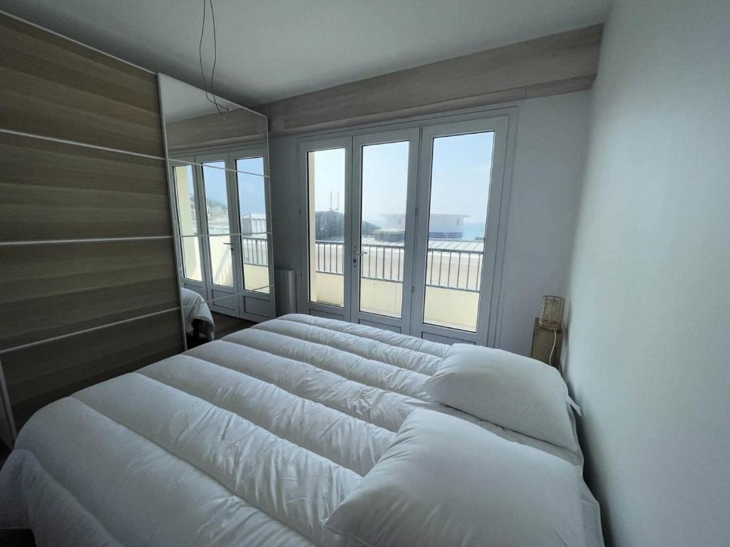een groot bed in een slaapkamer met een groot raam bij Résidence Casino - 2 Pièces pour 4 Personnes 474 in Pléneuf-Val-André