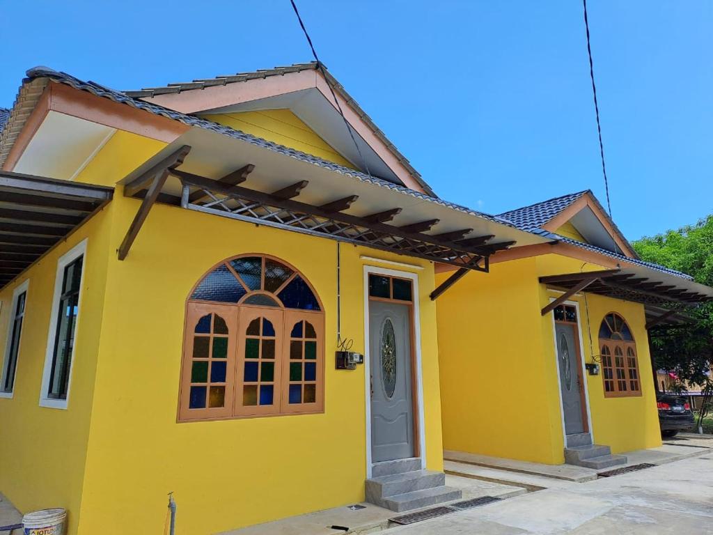 uma casa amarela com uma porta em Homestay Legasi Haji Ali em Kuala Terengganu