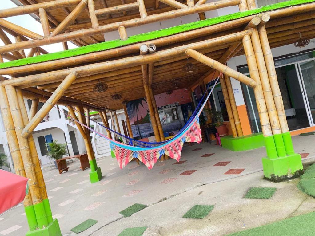 a porch with a hammock under a building at HOSTAL SINAGOGA in Montañita