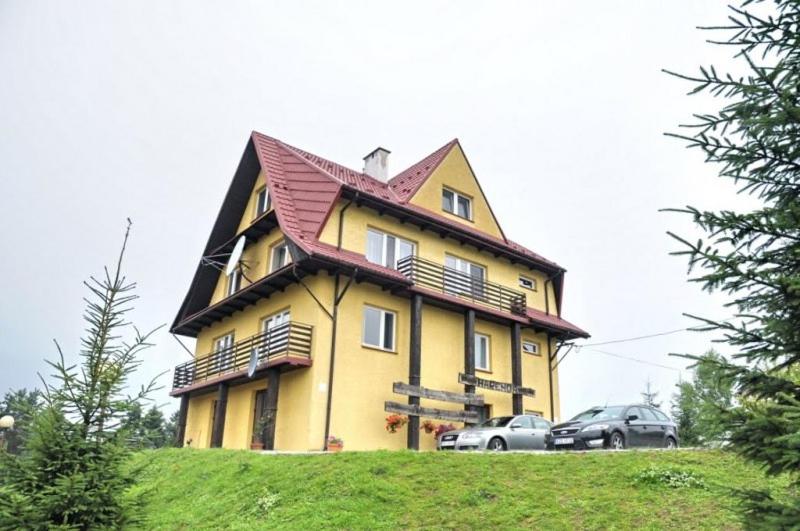 una casa con techo en la cima de una colina en SIEDLISKO HARENDA BIESZCZADY, en Czarna