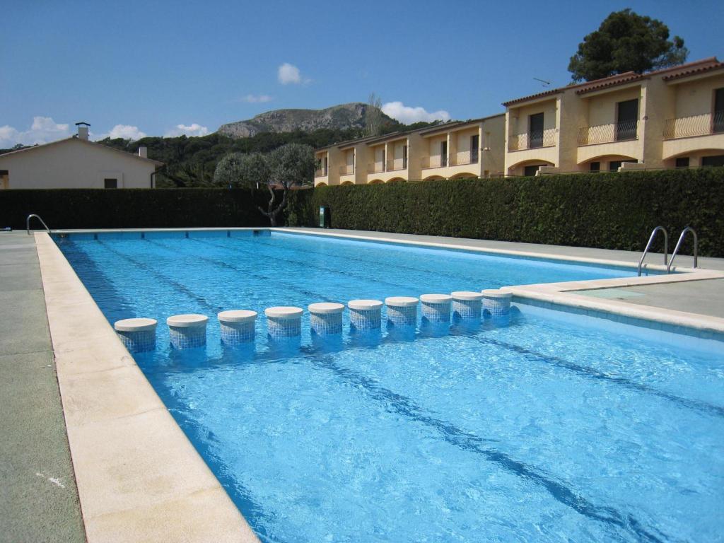 uma piscina com água azul em frente a um edifício em Casa L'Estartit, 2 dormitorios, 4 personas - ES-323-51 em L'Estartit