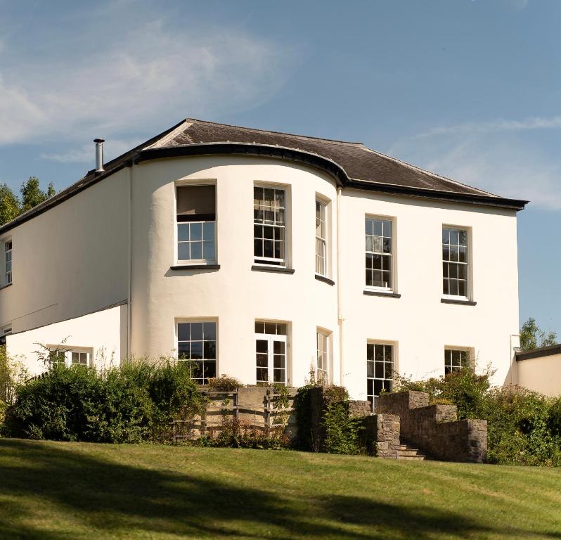 una casa blanca con techo negro en Holyland House - Greenacres Estates en Pembrokeshire