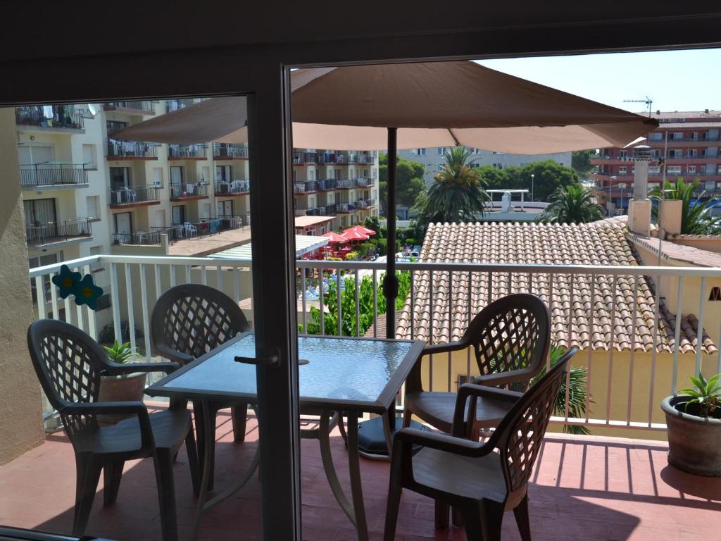 d'une table et de chaises sur un balcon avec un parasol dans l'établissement Apartamento L'Estartit, 2 dormitorios, 4 personas - ES-323-50, à L'Estartit