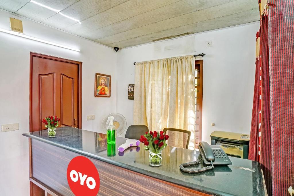 un bureau avec un bureau et un téléphone. dans l'établissement OYO Flagship 90284 Majestic Stays, à Kakkanad