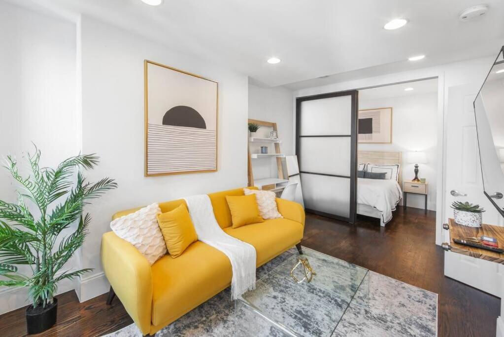 a living room with a yellow couch and a bed at 69-5B I Stylish Lower East Side 1BR Apt BRAND NEW in New York
