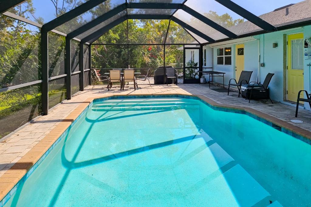 a swimming pool with a pergola and a house at Away from it All Abode in Sanibel