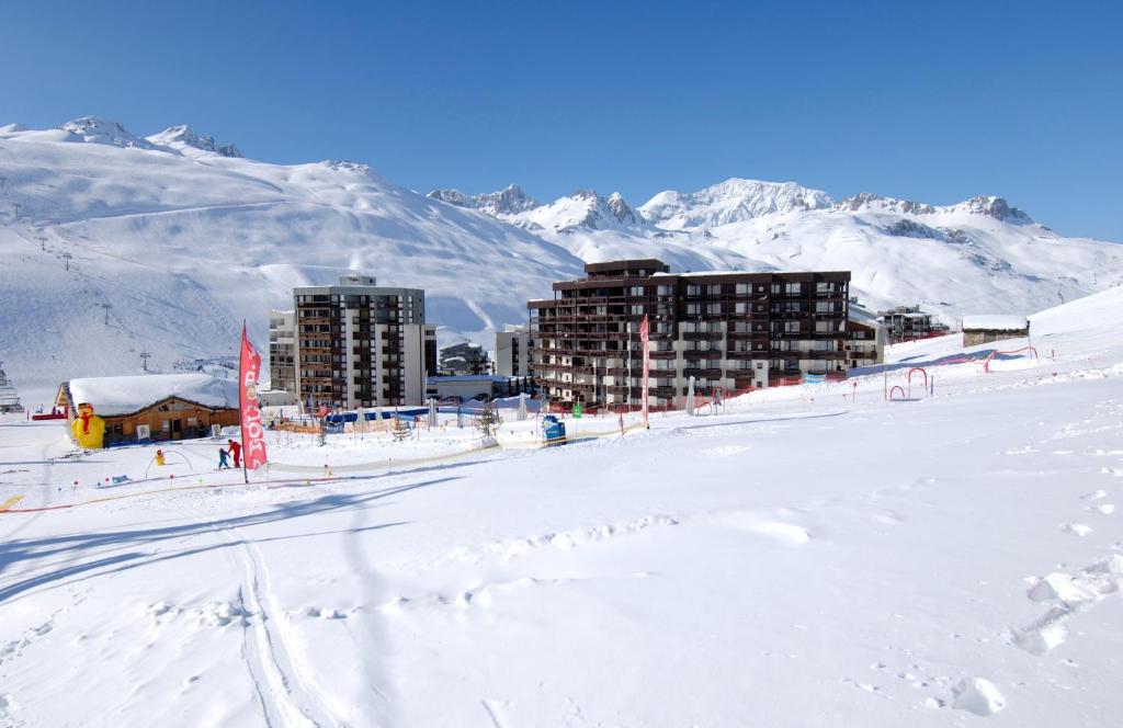 una estación de esquí en la nieve con montañas en el fondo en Résidence Odalys Le Hameau du Borsat en Tignes