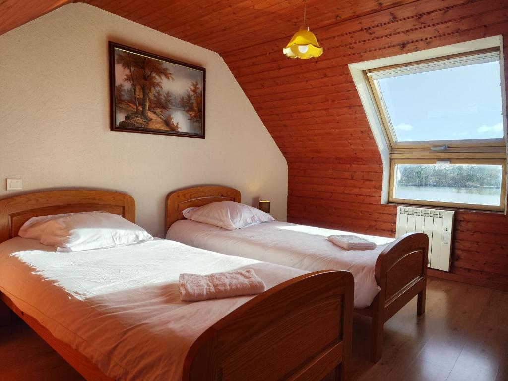 2 camas individuales en una habitación con ventana en Domaine de la roselière • Nature • Brenne, en Rosnay