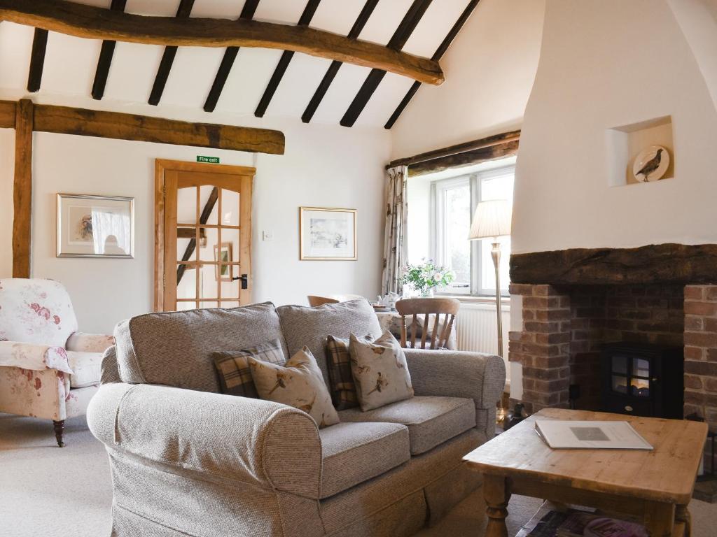 a living room with a couch and a fireplace at Tophams Laithe in Kilnsey