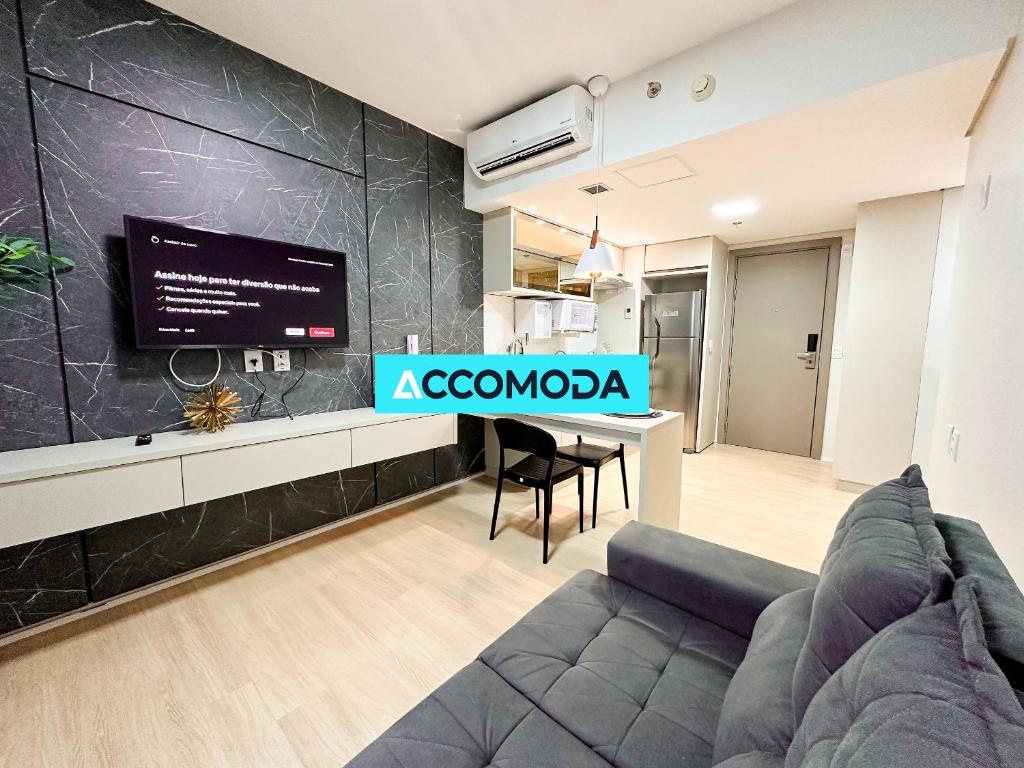 Habitación con sofá y TV en la pared. en Studio Decorado | 800m Órion Business | St Marista, en Goiânia