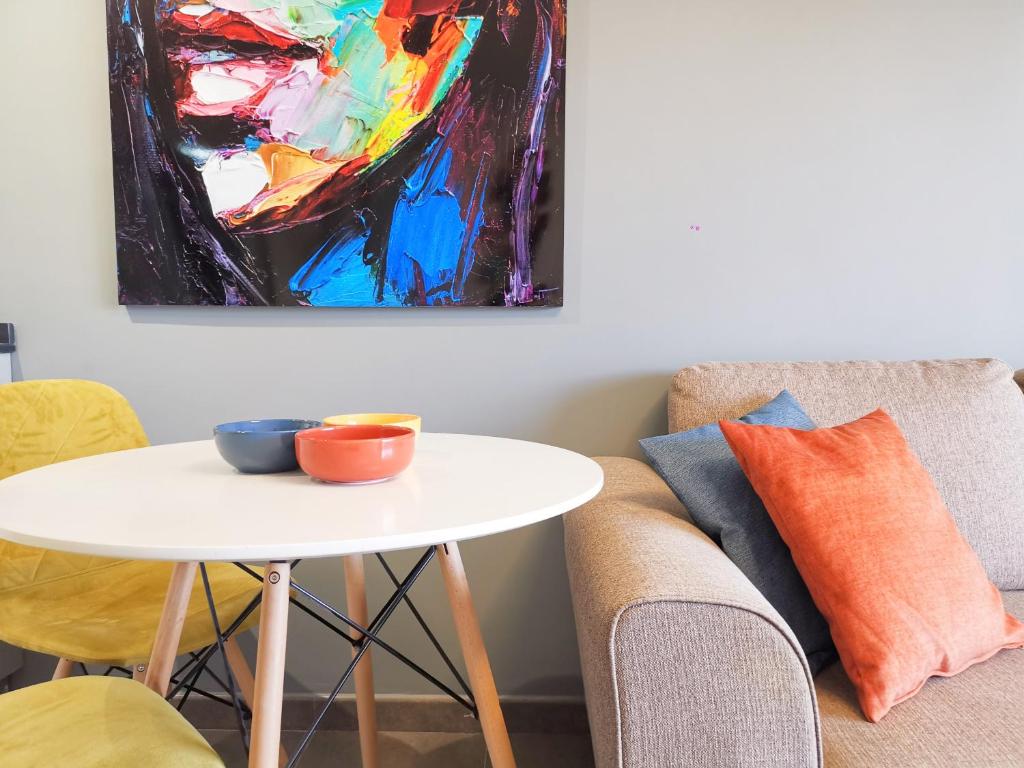a table in a living room with a painting on the wall at Iguazu 210 Stylish Home By Pride Holiday Rentals in Maspalomas