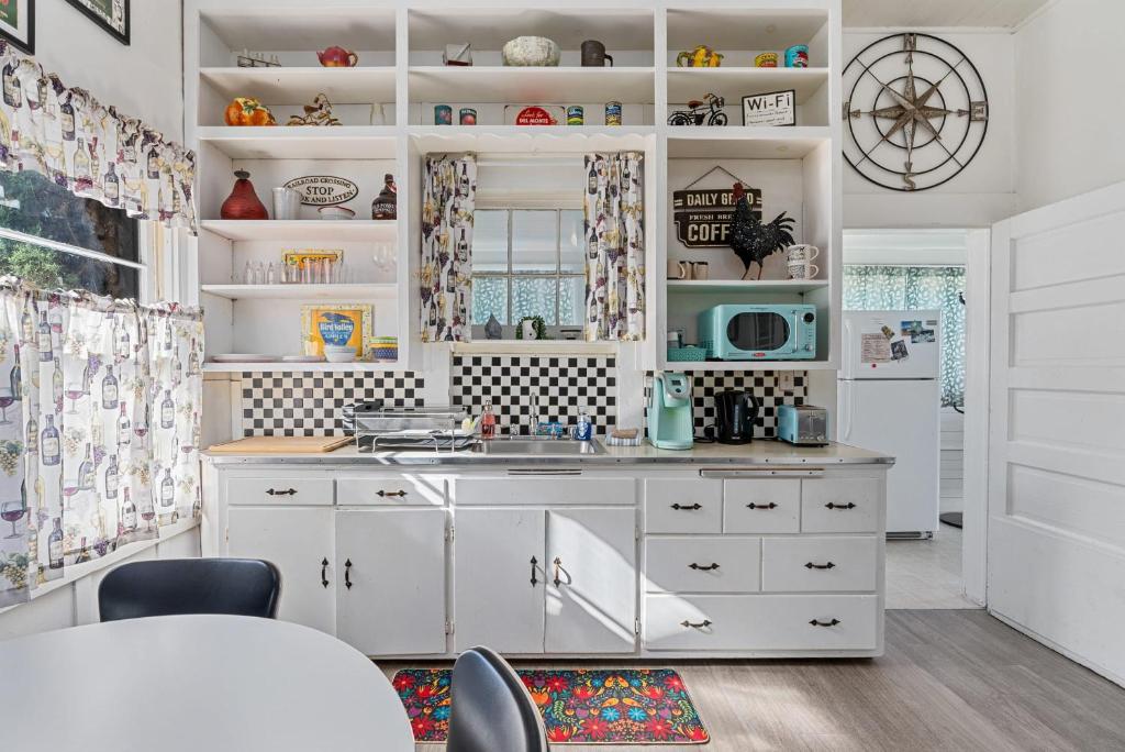 a kitchen with white cabinets and a sink at Downtown Urban Flat - close to SMART Station in Santa Rosa