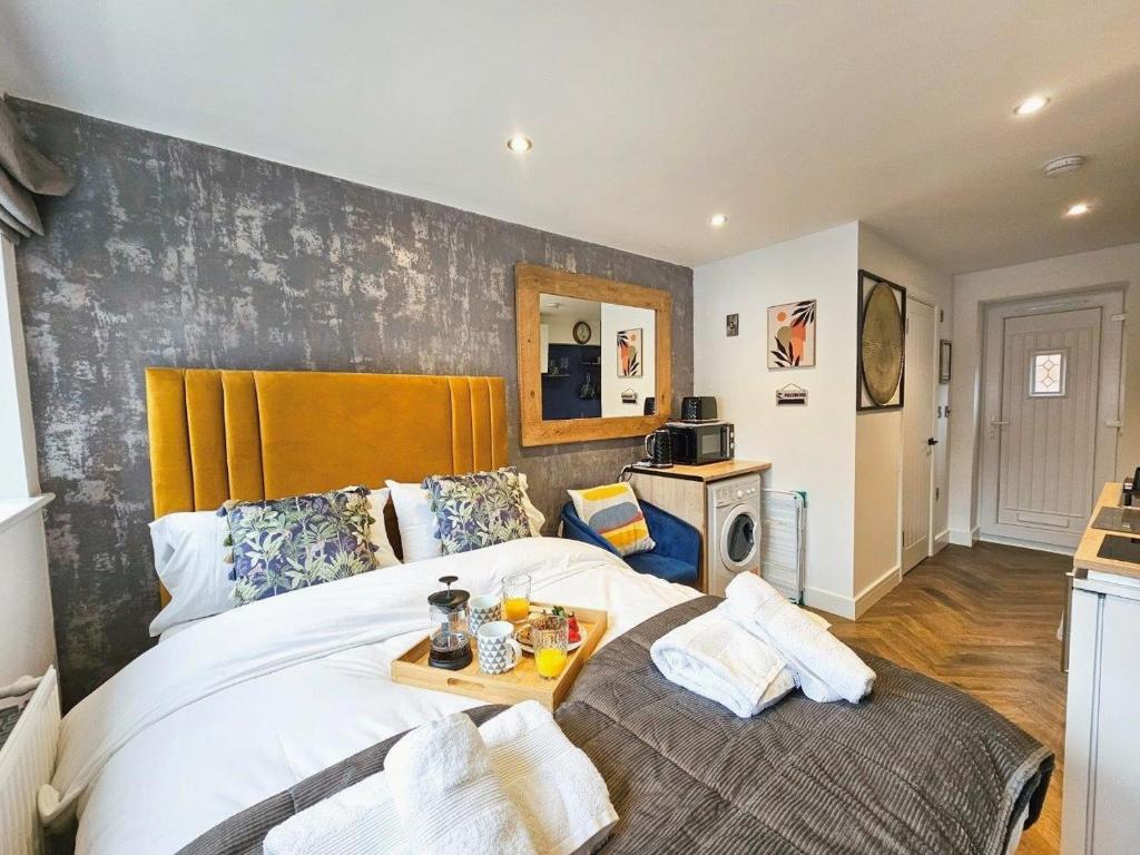 Un dormitorio con una cama grande y una mesa. en Cobblestone Studio en Cheltenham