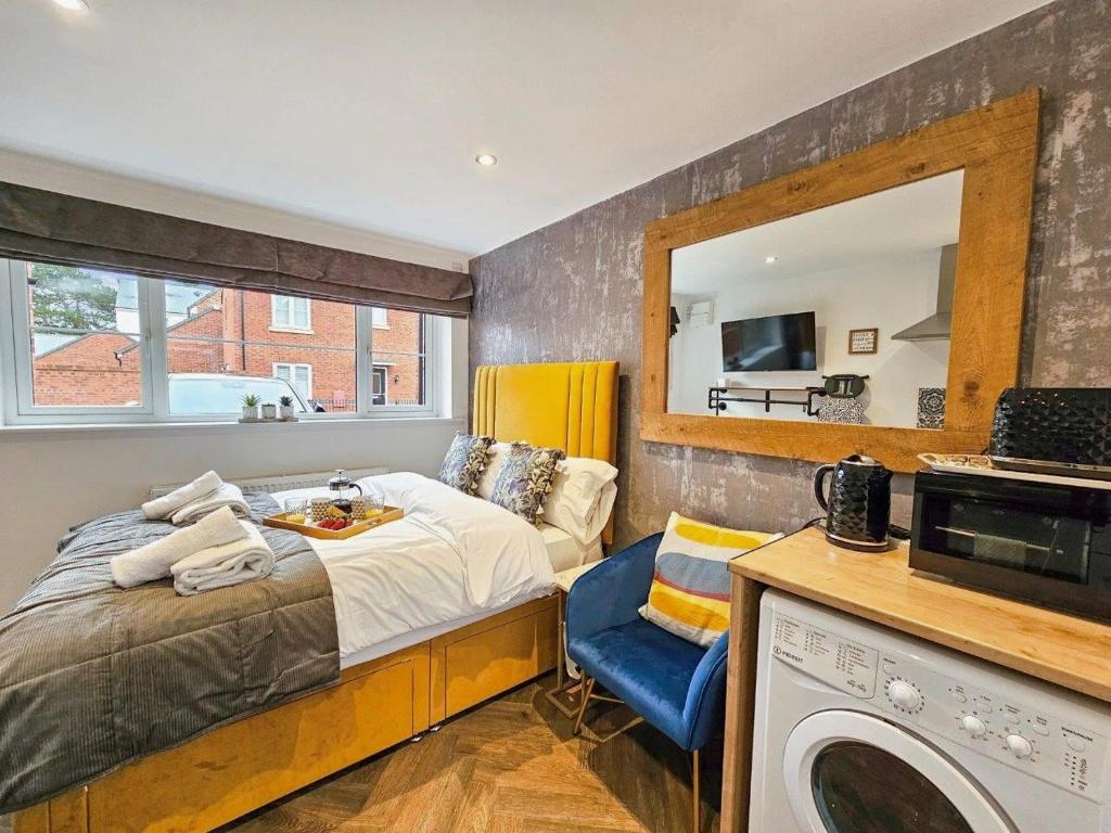 Hotel Cobblestone Studio by Fortuna Property, a bedroom with a bed and a mirror at Cobblestone Studio by Fortuna Property in Cheltenham