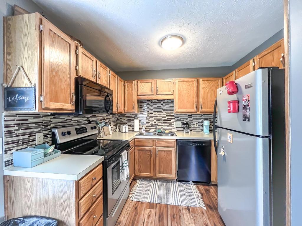 a kitchen with wooden cabinets and a white refrigerator at New 3 bd 2 bath Hot tub in Omaha