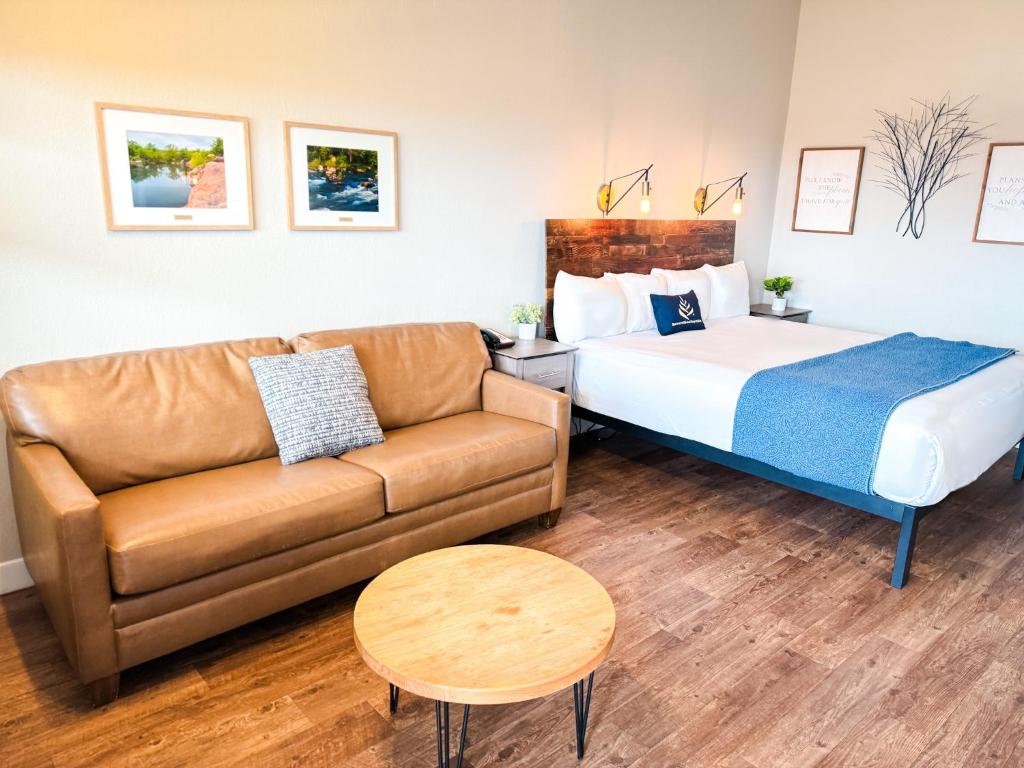 une chambre d'hôtel avec un lit et un canapé dans l'établissement PINEMARK Inn Suites Events, à Saint Clair