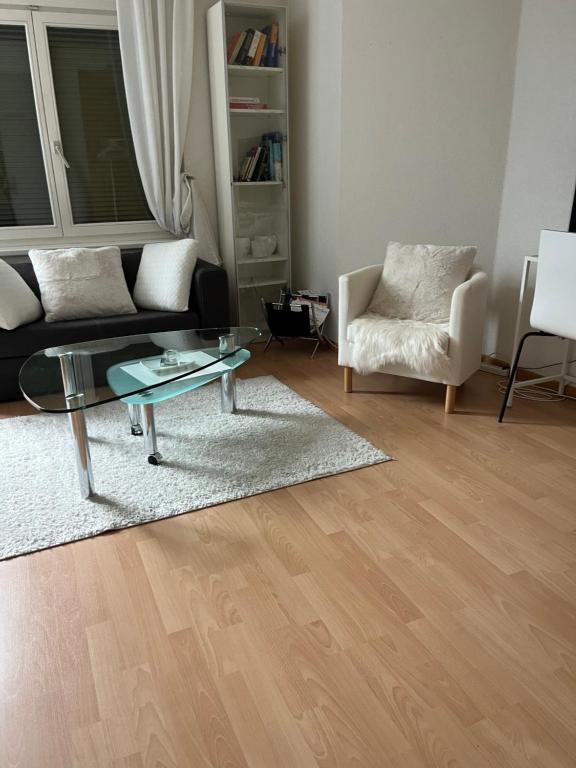 un soggiorno con divano, tavolo e sedia di over-night City-Flat a St. Gallen