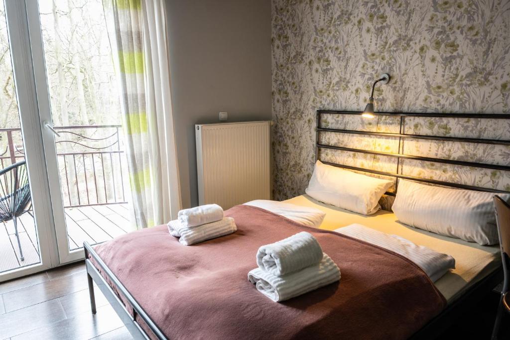 a bedroom with a large bed with towels on it at Villa Pasja in Świnoujście