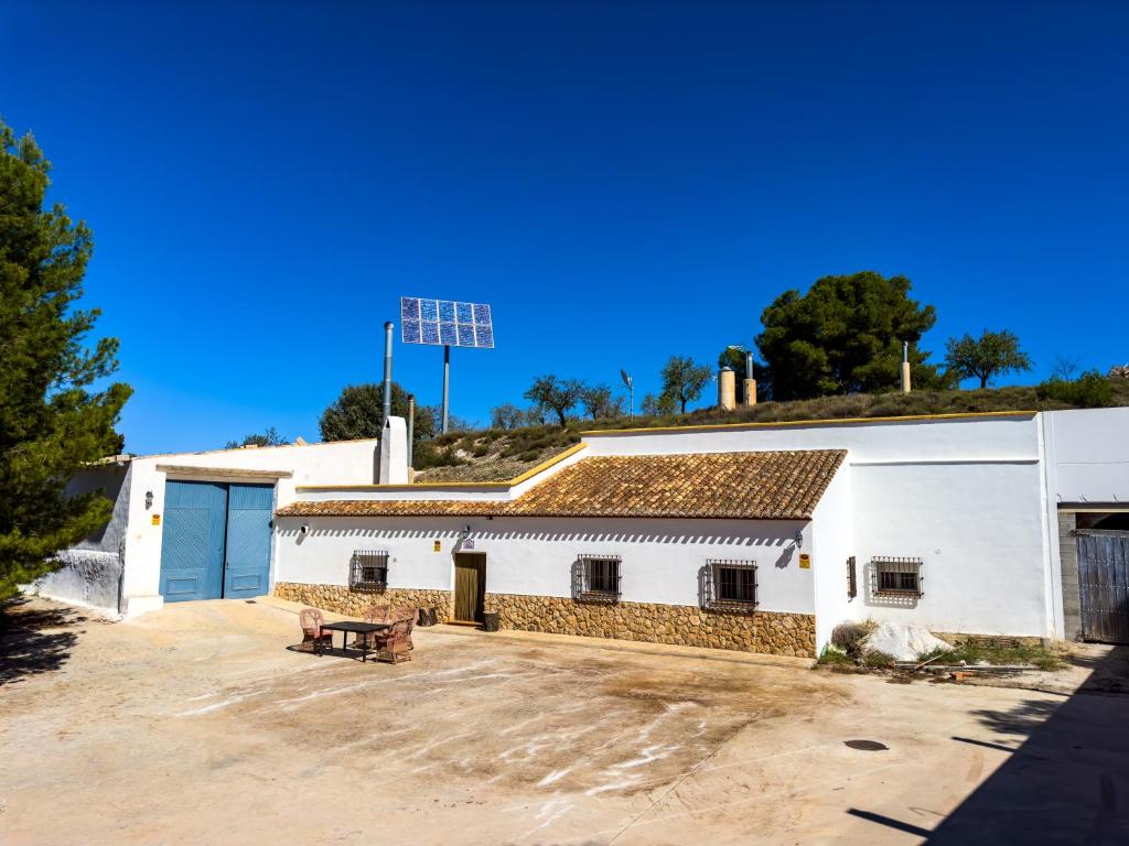 een groot wit gebouw met een parkeerplaats bij Cortijo Martínez Santaolalla in Pulpite