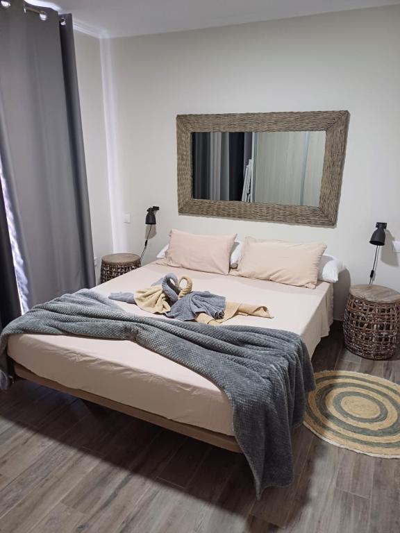 sypialnia z łóżkiem z kocem i lustrem w obiekcie Casa Esterlita w mieście Tarajalejo