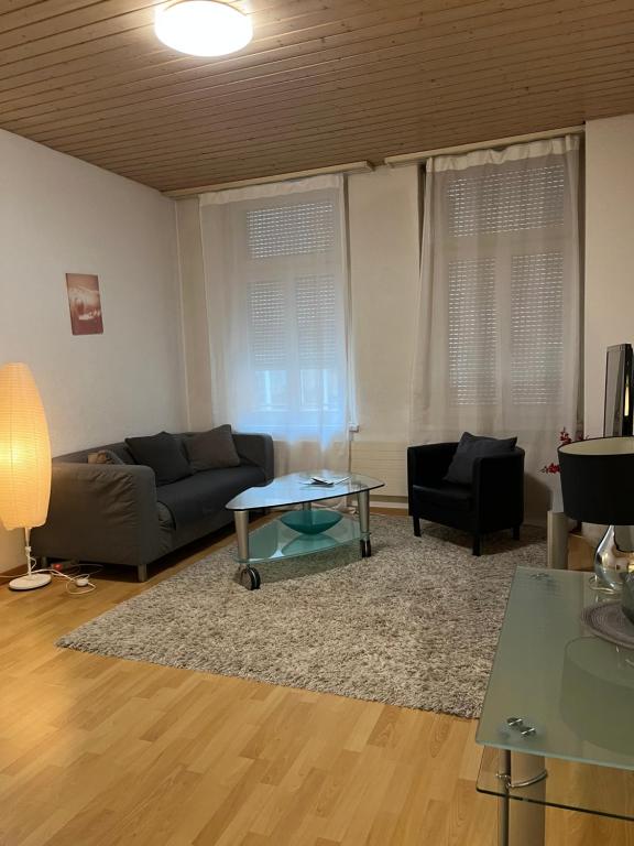 uma sala de estar com um sofá e uma mesa em room service Joppich em St. Gallen