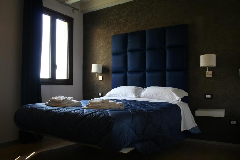una camera con un grande letto con testiera blu di Bamboo Luxury B&B a Agrigento