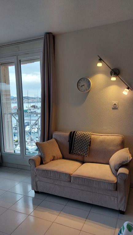 a couch sitting in a living room with a window at Apartment Hirondelle Port Frejus in Fréjus