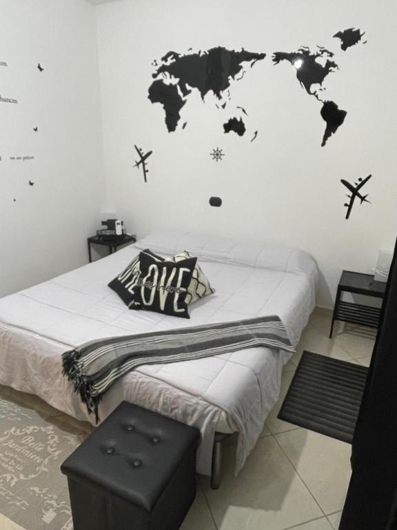 1 dormitorio con 1 cama con un mapa mundial en la pared en Camere Aeroporto Cagliari Elmas, en Elmas