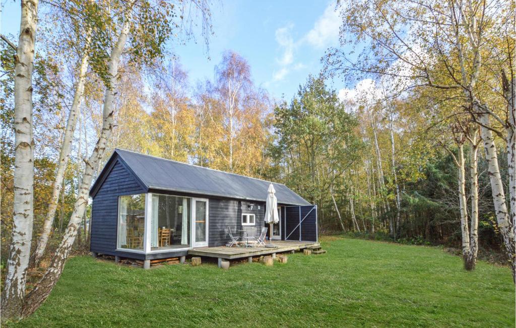 uma pequena casa preta no meio de um campo em Lovely Home In Askeby With Wifi em Askeby