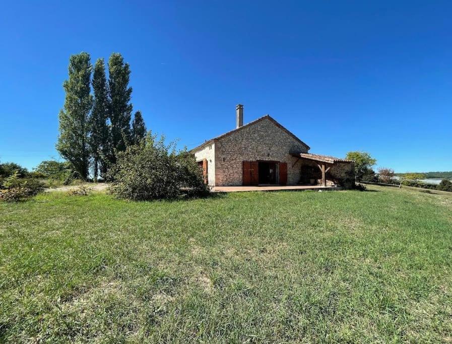 une maison sur une colline avec une pelouse dans l'établissement Gîte au cœur des vignes, à Cazes-Mondenard