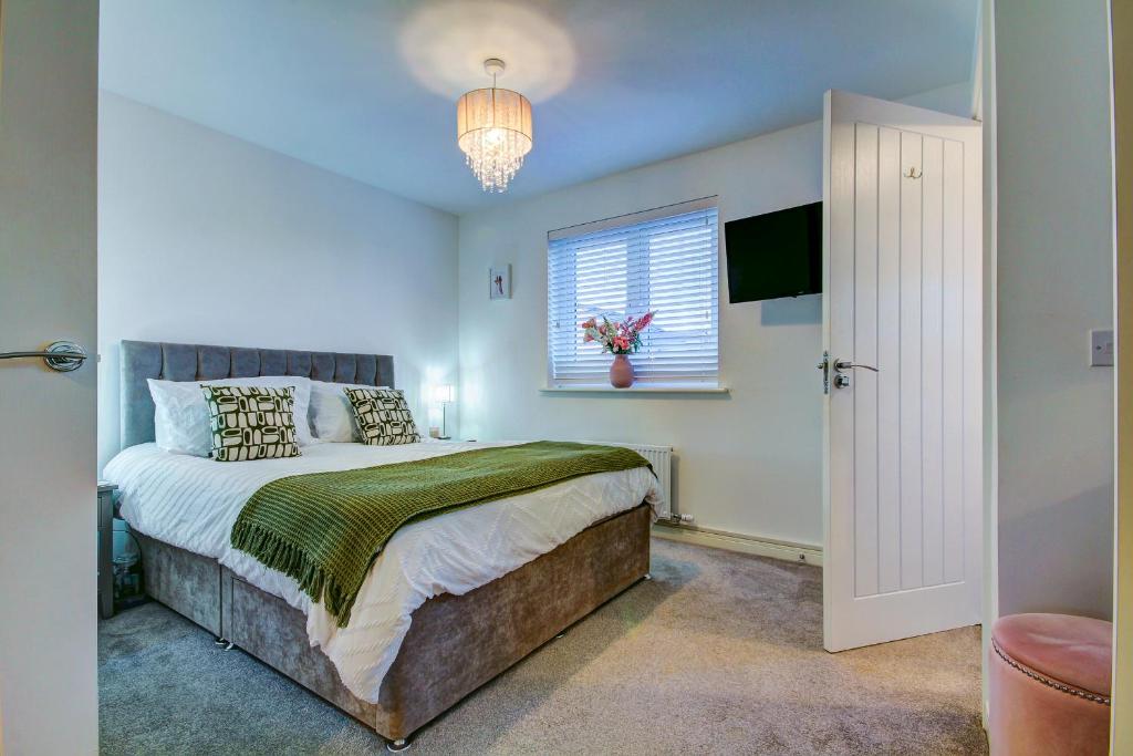 Un dormitorio con una cama grande y una ventana en St Andrews Park - Coorie Doon Stays, en Troon