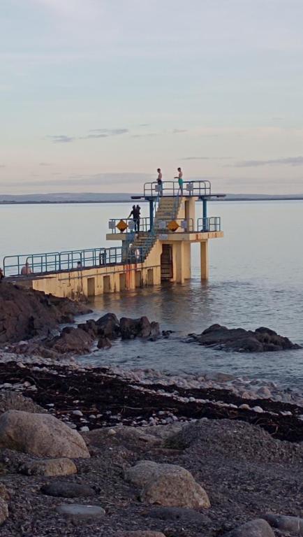 people standing on a pier over the water at Salthill Stay B&B in Galway