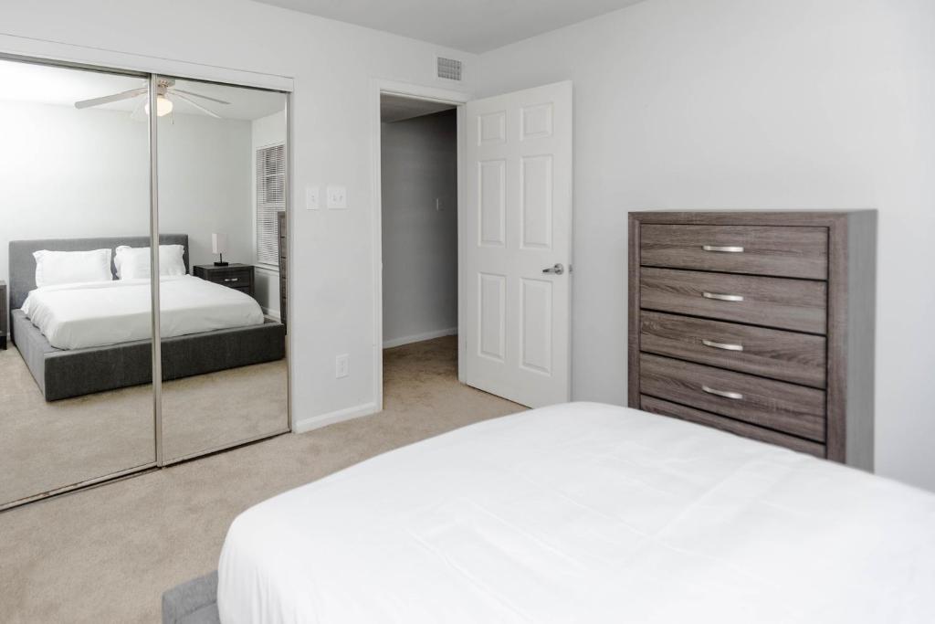 a bedroom with a white bed and a large mirror at Modern Luxe 2bd2ba I Free Parking I Wyndham in Hampton