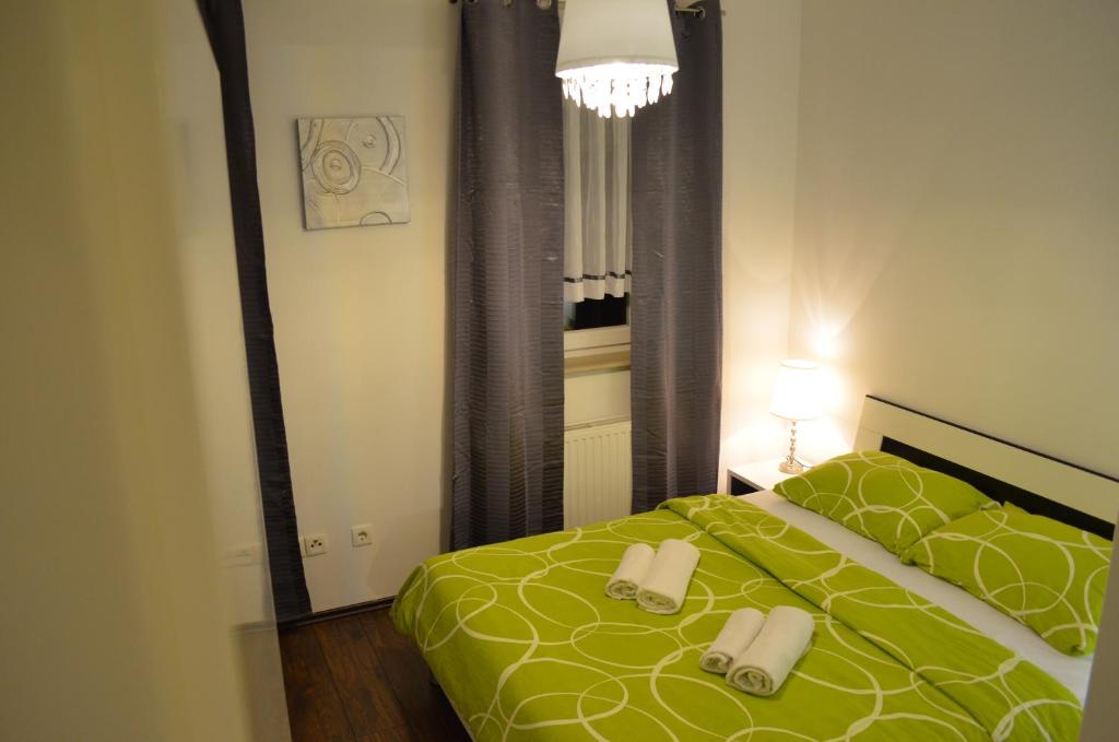 a bedroom with a green bed with towels on it at Apartment Meli in Sesvete