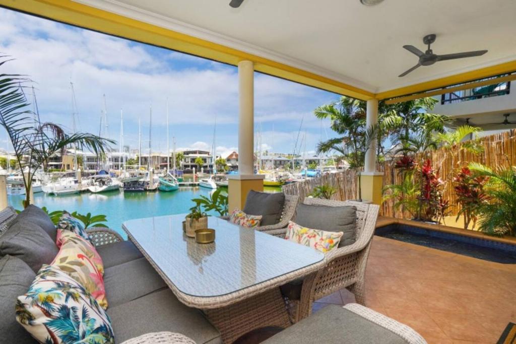 een patio met een tafel en stoelen en een jachthaven bij Marina View - Waterfront Stunner with Plunge Pool in Darwin