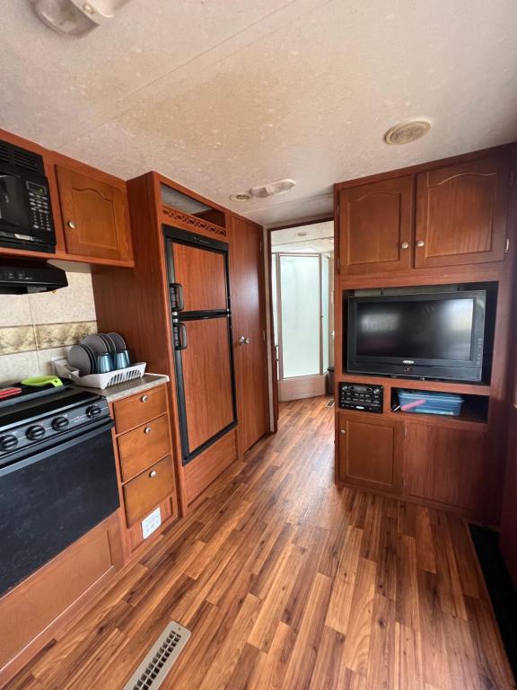 cocina con armarios de madera, microondas y TV en Casa Nectar, en Temalhuacán