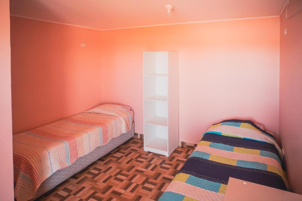 Dormitorio pequeño con cama y estante en Hostal el hermanito, en San Pedro de Atacama