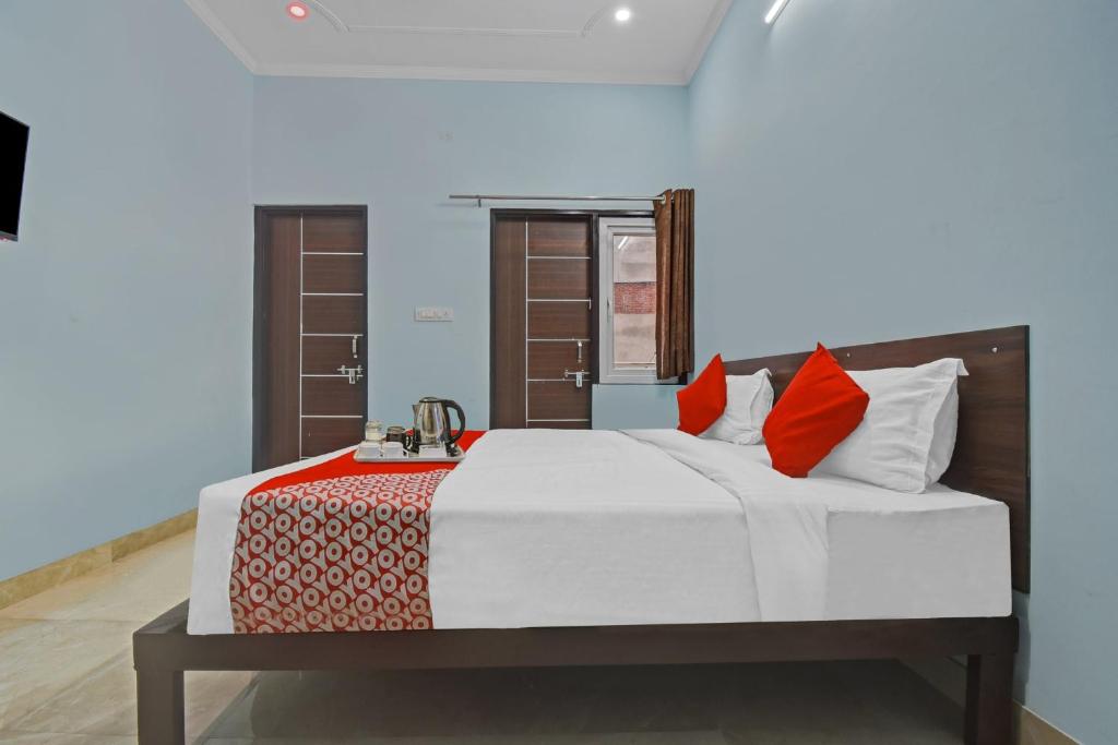 a bedroom with a large bed with red pillows at Flagship Hotel Ansh Plaza in Jaipur