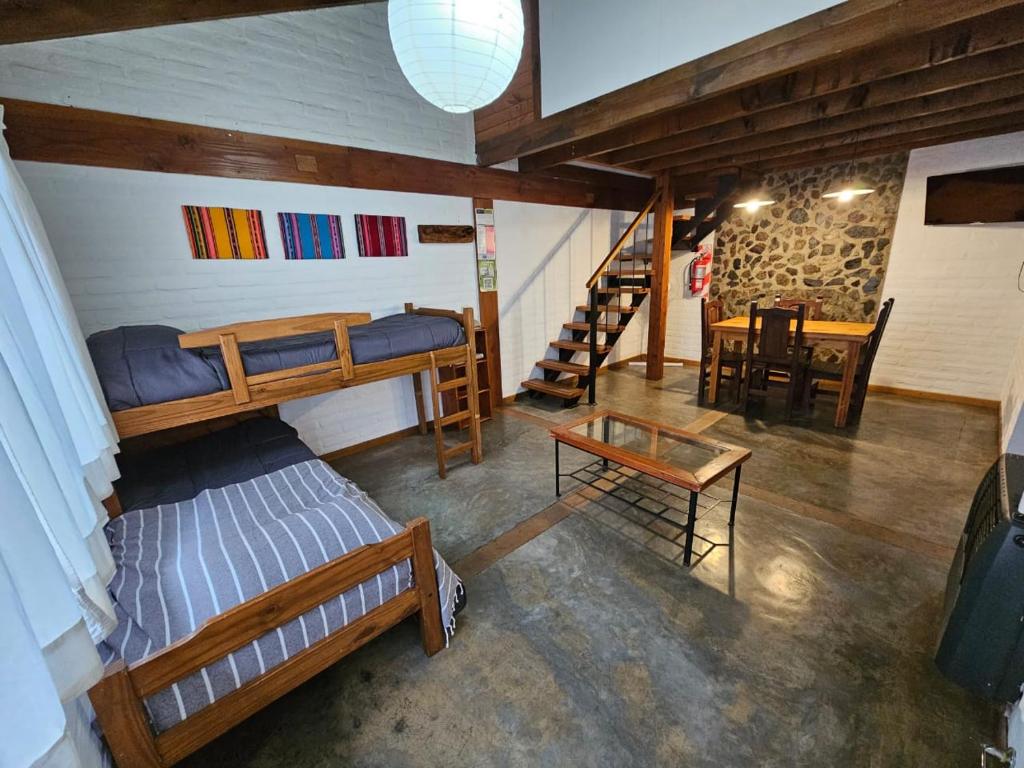 Cette chambre comprend 2 lits superposés et une table. dans l'établissement Punto Sur Cabañas, à El Bolsón