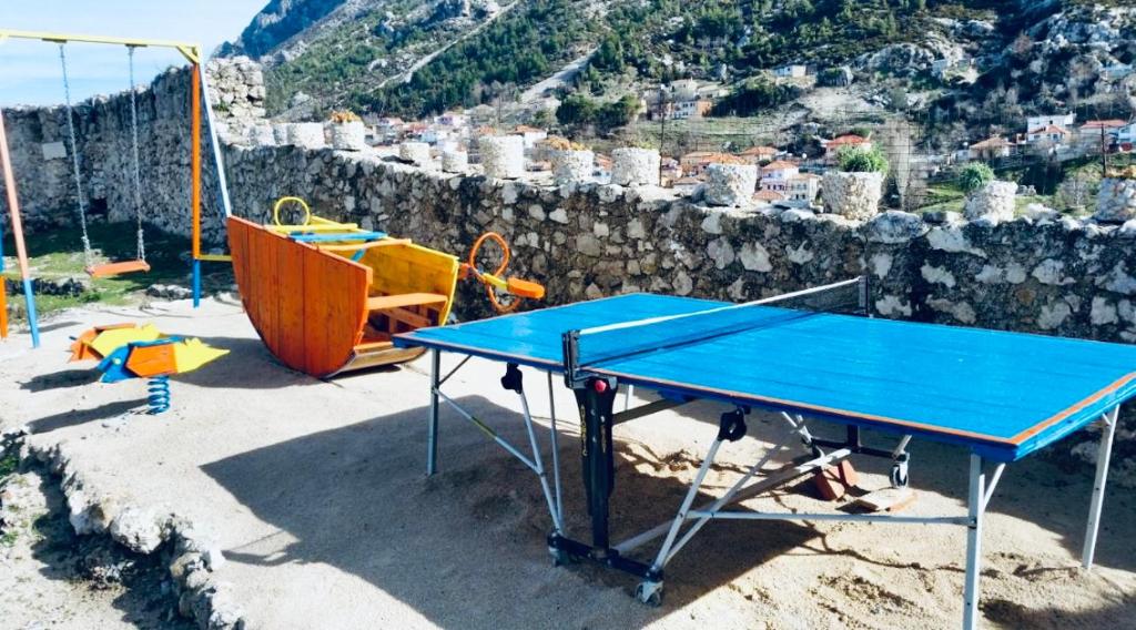 uma mesa de pingue-pongue azul num parque infantil em ROOMS EMILIANO Castle of Kruja em Krujë