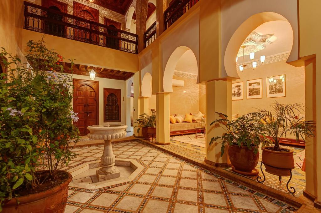 a lobby with a fountain and potted plants at Riad Amalia in Marrakesh