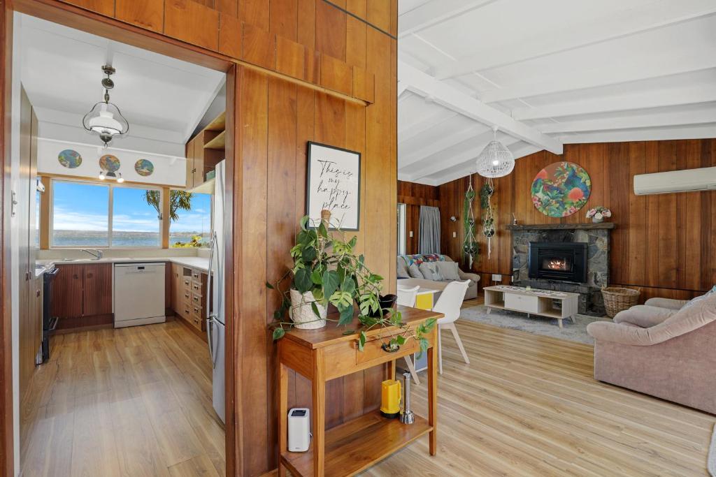 cocina y sala de estar con paneles de madera en Hannah's Bay Lakefront, en Rotorua