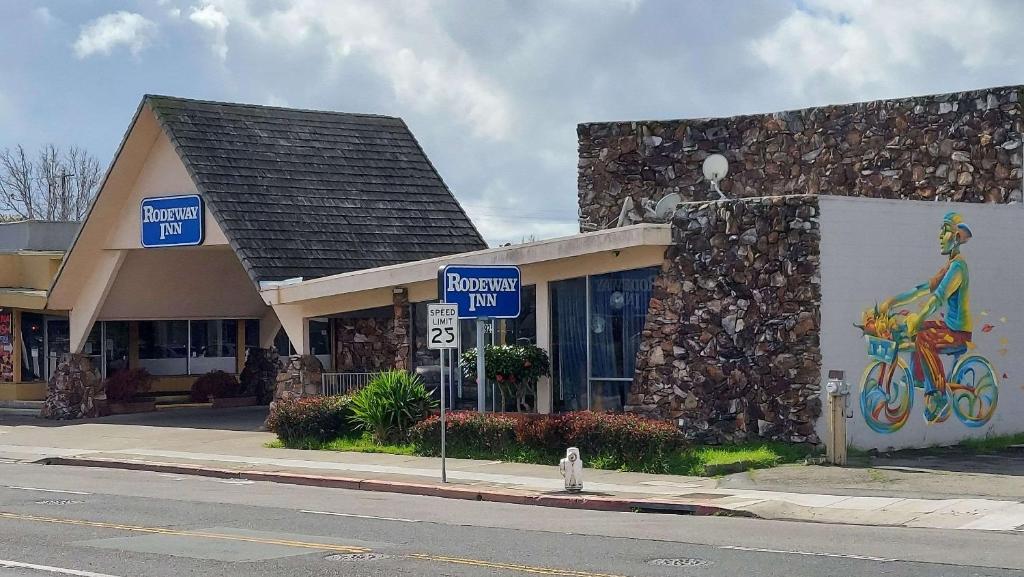 un edificio con un mural de una mujer en bicicleta en Rodeway Inn Alameda-Oakland, en Alameda