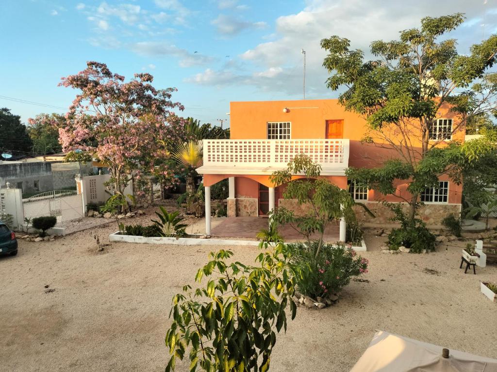 an orange house with trees in front of it at Casa en VILLA GABRIELA in Celestún