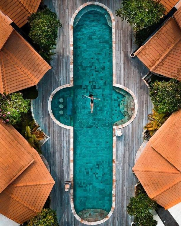 an overhead view of a swimming pool with a person in the water at Pondok Baruna Frangipani in Nusa Lembongan