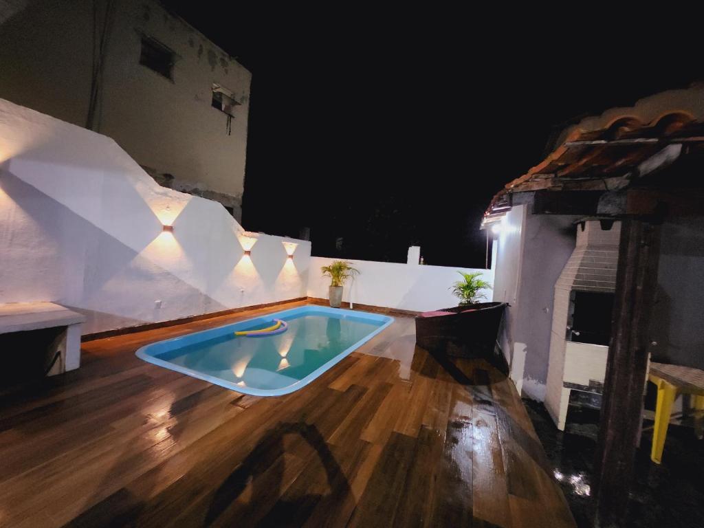 サクアレマにあるCasa piscina 8 pessoasの夜の家屋の床にあるスイミングプール
