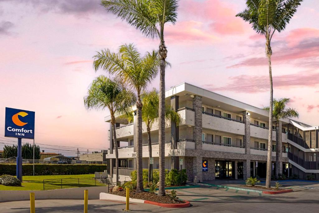 an office building with palm trees in front of it at Comfort Inn Sea World Area in San Diego